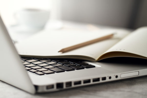 Closeup of Workspace with Modern Creative Laptop, Cup of Coffee and Pencils. Horizontal with Copy Space.